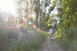 un jeune homme en costume de sport gris court le long du chemin parmi les photo