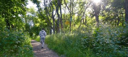 un jeune homme en costume de sport gris court le long du chemin parmi les photo