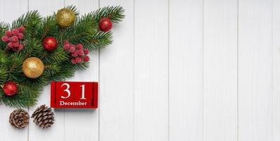 fond de nouvel an avec sapin décoré et calendrier perpétuel rouge de cubes photo
