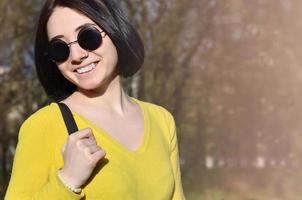 une fille joyeuse dans un chandail jaune vif traverse le sprin photo
