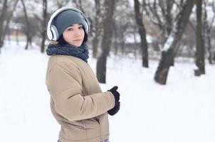 portrait d'hiver de jeune fille avec des écouteurs photo