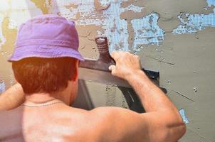 Ouvrier manuel de cinquante ans avec des outils de plâtrage de mur rénovant la maison. plâtrier rénovant les murs et les coins avec une spatule et du plâtre. installation de purée murale. travaux de finition du bâtiment photo