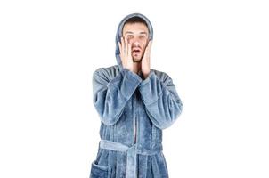 portrait de jeune homme barbu caucasien en peignoir bleu avoir peur isolé sur fond blanc photo