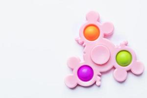pop it fidget jouet. jouet anti-stress multicolore avec une forme d'aile sur fond blanc photo