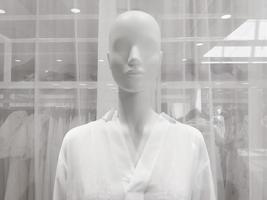 Mannequin femme blanche dans la fenêtre du magasin de vêtements, gros plan photo