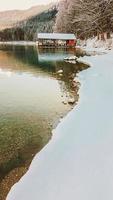 paysage d'hiver, lac alpin, stockage de bateaux recouvert de neige photo