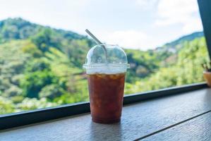 café noir sur une barre en bois avec fond de colline de montagne photo