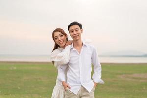 heureux jeune couple asiatique en vêtements de mariée et de marié photo