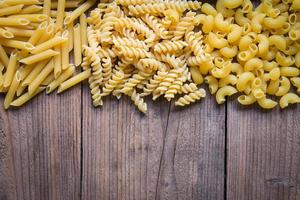 fond de pâtes, fond de texture de macaroni cru, pâtes penne et pâtes en spirale pâtes délicieuses non cuites pour la cuisson des aliments photo