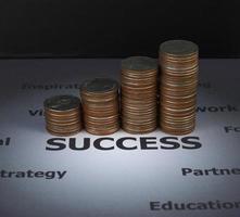 concept de finance et d'investissement - pile de pièces sur le mot de succès qui entourent d'autres facteurs pour réussir - gagner beaucoup d'argent en cas de succès photo