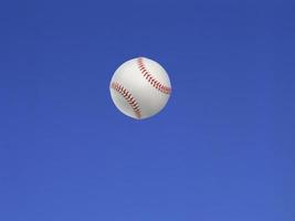 balle de baseball tirée en l'air avec fond de ciel bleu photo