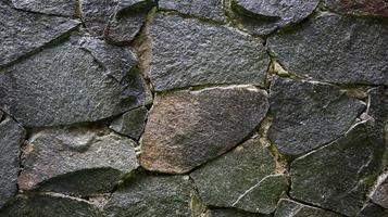 la photo de la texture du mur de pierre semble vieille et humide pour le papier peint et l'arrière-plan.