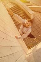 un jeune homme surmonte des obstacles, grimpant sur des murs en béton. l'athlète pratique le parkour, s'entraînant dans des conditions de rue. le concept de sous-cultures sportives chez les jeunes photo