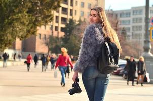 vue arrière d'une fille avec un appareil photo numérique sur une rue bondée ba