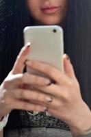 la jeune fille brune utilise un smartphone tactile moderne photo