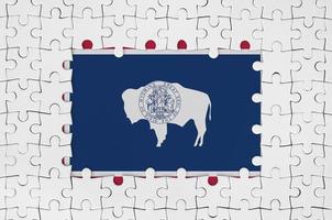 drapeau de l'état américain du wyoming dans le cadre de pièces de puzzle blanches avec partie centrale manquante photo