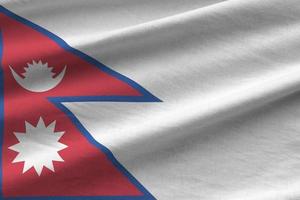 drapeau népalais avec de grands plis agitant de près sous la lumière du studio à l'intérieur. les symboles et couleurs officiels de la bannière photo