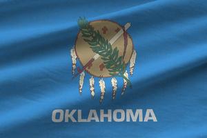 drapeau de l'état américain de l'oklahoma avec de gros plis agitant de près sous la lumière du studio à l'intérieur. les symboles et couleurs officiels de la bannière photo