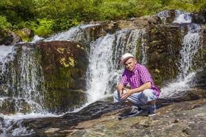 homme touriste devant la belle cascade de la rivière vang norvège. photo