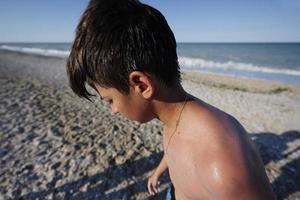 gros plan sur un garçon mouillé après avoir nagé en mer à la plage porto sant elpidio, italie. photo