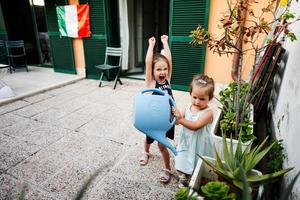 deux soeurs avec bidon arrosant les fleurs sur la terrasse de la maison. photo