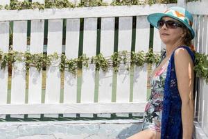 femme portant un maillot de bain une pièce et une couverture bleue traîner près d'une piscine par une journée ensoleillée photo