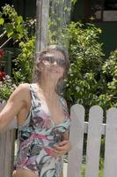 femme se rinçant sous la douche au bord de la piscine photo