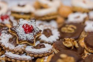 différents biscuits de noël savoureux avec des cerises rouges et des noix blanches photo