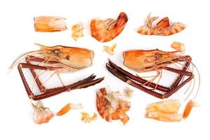 têtes de crevettes et carapaces de crevettes, déchets alimentaires, restes, déchets. fruits de mer naturels. déjeuner. dîner isolé sur fond blanc. photo