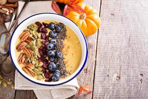 bol de smoothie à la citrouille avec graines de chia, pacanes, canneberges photo