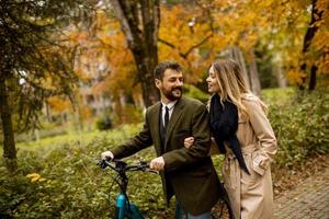 jeune couple dans le parc d'automne avec vélo électrique photo