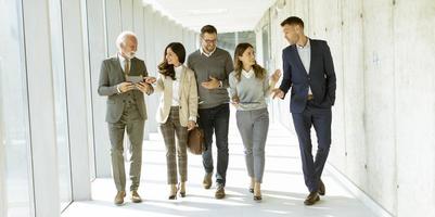 groupe de professionnels d'entreprise marchant dans le couloir du bureau photo