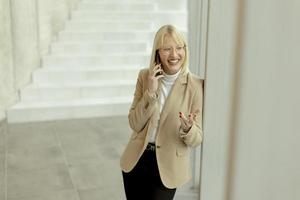 femme d'affaires utilisant un téléphone portable dans un couloir de bureau moderne photo