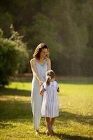 jolie petite fille s'amusant sur une herbe avec sa mère photo