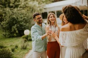 groupe de jeunes heureux acclamant avec de la limonade fraîche dans le jardin photo