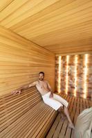 jeune homme se détendre dans le sauna photo