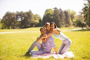 jeune famille heureuse avec une petite fille mignonne s'amusant dans le parc par une journée ensoleillée photo