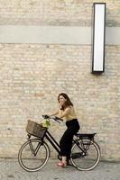 femme avec des fleurs dans le panier du vélo électrique photo