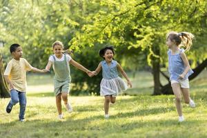 groupe d'enfants asiatiques et caucasiens s'amusant dans le parc photo