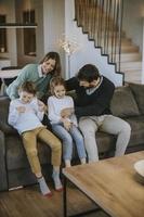 une famille heureuse avec deux enfants passe du temps ensemble sur un canapé dans le salon photo