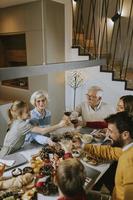 famille heureuse en train de dîner avec du vin rouge à la maison photo