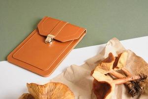 petit sac marron et champignons vénéneux sur fond vert, éco-cuir de mycélium de champignon photo