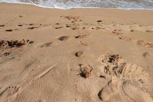 empreintes de pas dans la belle plage de sable photo