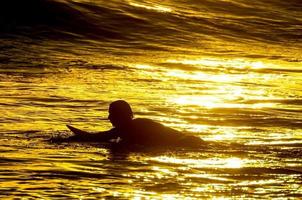 surfeur silhouette au coucher du soleil photo