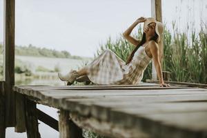 jeune femme relaxante sur une jetée en bois au bord du lac photo