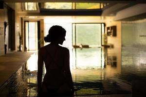 vue arrière d'une jeune femme se reposant au bord de la piscine photo