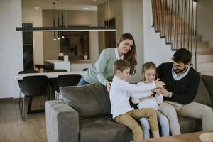 Frères et sœurs se disputant la télécommande du téléviseur à la maison photo