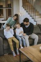 une famille heureuse avec deux enfants passe du temps ensemble sur un canapé dans le salon photo