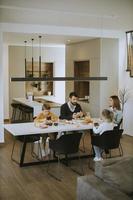 famille utilisant des téléphones portables tout en prenant son petit déjeuner à la table à manger de l'appartement photo