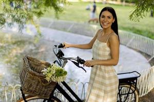 jeune femme avec vélo électrique et fleurs dans le panier photo